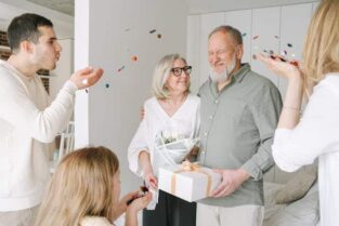 Joyful anniversary celebration with friends, balloons, and cake, showcasing FoodArt’s anniversary catering services.